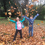 Image of children throwing leaves in the air