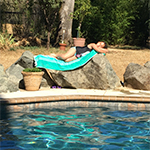 Image of young girl laying by the pool