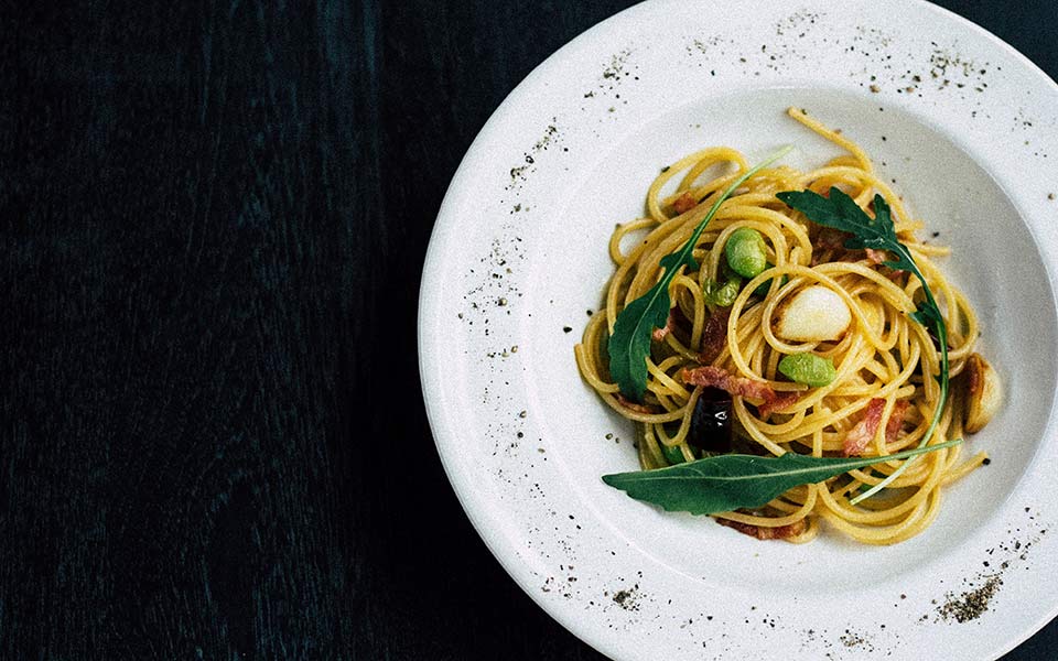 Pasta with leafy greens on dinner plate