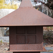 A close-up of a bronze-colored streetlight-like object.