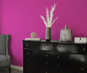 Deep, dark pink wall behind dresser