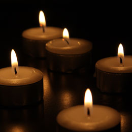 picture of small candles burning with a dark background