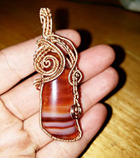 Orange carnelian wrapped in copper wire 