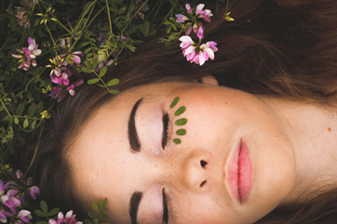 girl with eyes closed and leaves on face
