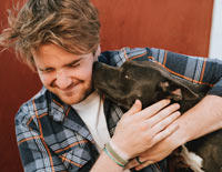 man getting licked by dog