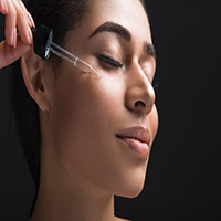 woman applying facial serum