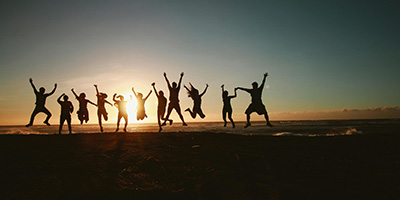 our team jumping at a beach during sunset