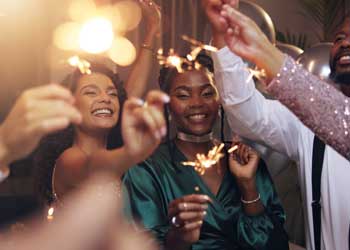 people holding sparklers and smiling