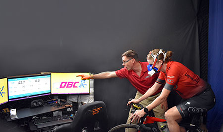 coach encouraging a cyclists during a VO2 max test