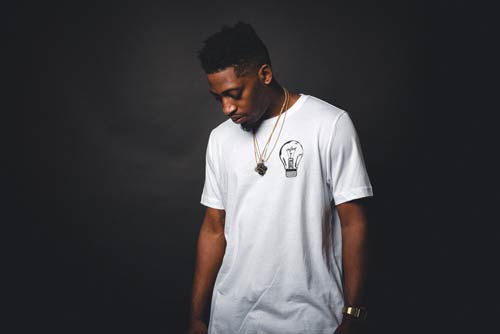 man wearing a white t-shirt posing looking down