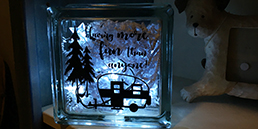 black decal backlit on a 6 by 6 glass block that has a vintage trailer, palm trees and says having more fun than anyone