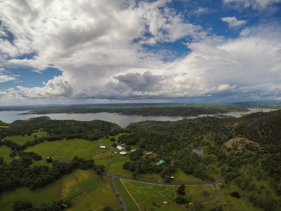 a lake with thunderstorms behind it