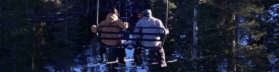 Boarders sitting together up lift